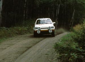 Rod Millen / Tony Sircombe fly over a crest in preparation for an upcoming 90 right in their Mazda 323GTX.