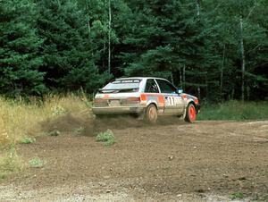 Jeff Zwart / Cal Coatsworth in their Mazda 323GTX hit the gas at the exit of a hairpin.