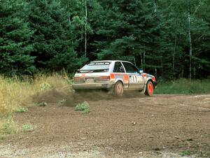 Jeff Zwart / Cal Coatsworth in their Mazda 323GTX hit the gas at the exit of a hairpin.