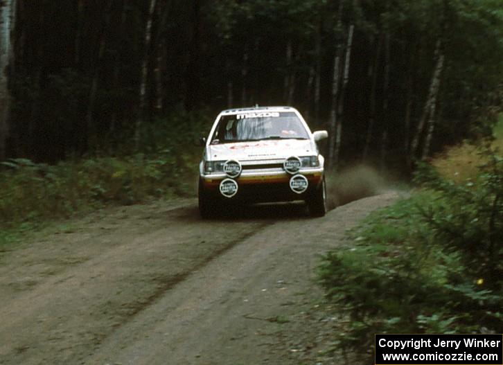 Rod Millen / Tony Sircombe fly over a crest in preparation for an upcoming 90 right in their Mazda 323GTX.