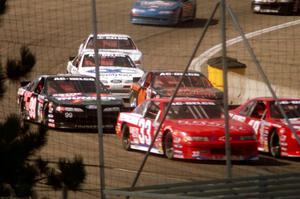 A gaggle of cars come through turn 4