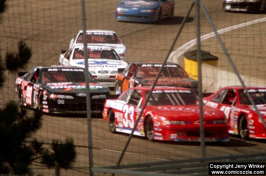 A gaggle of cars come through turn 4