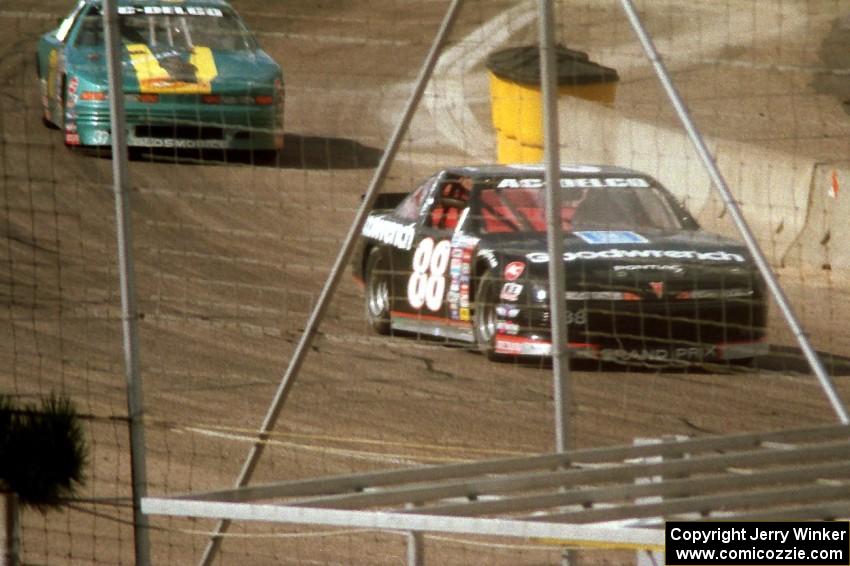 Mike Eddy's Pontiac Grand Prix and David Anspaugh's Olds Cutlass come out of turn 4