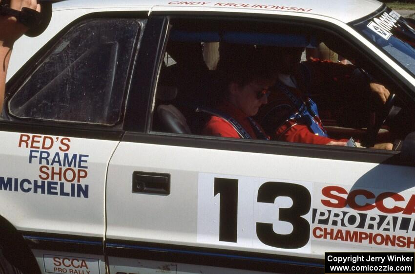 Cindy Krolikowski reads notes before laving the ceremonial start in her and her husband's (Henry Krolikowski) Dodge Shadow.