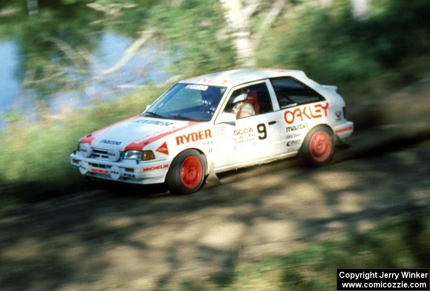 Jeff Zwart / Cal Coatsworth in their Mazda 323GTX blast past one of the many picturesque lakes.