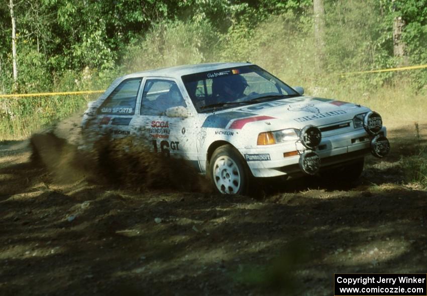 Shannon Millen / Jean Lindamood Mazda 323GTX blast dirt while taking a left-hand hairpin.