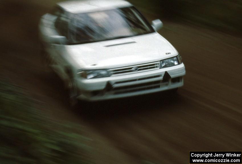 The new factory Subaru Legacy of Chad DiMarco / Erick Hauge flies down a tree-lined Blue Trail.