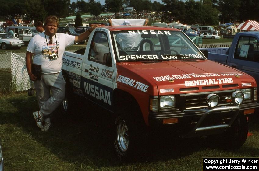 Norm Johnson leans on the Spencer Low Racing Nissan Pickup on display
