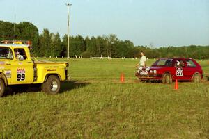 Brenda Corneliusen, in J.B. Niday's VW GTI, gets pulled out of the muck by Dan MacDonald's Chevy Pickup as John Parker watches.