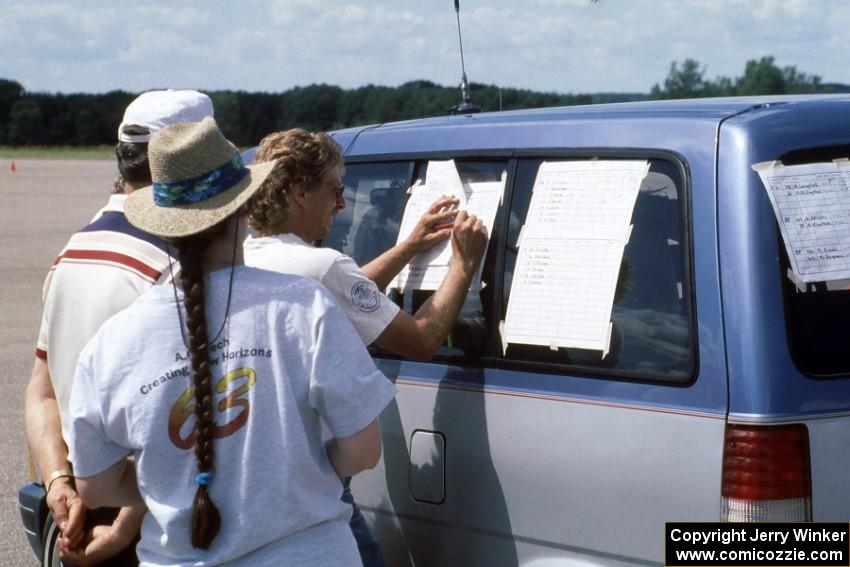 Jerome Sybrant writes down the scores as a few others check the scoreboards