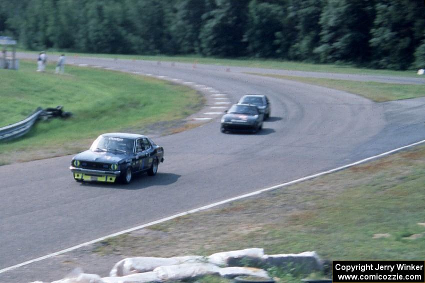 John Glowaski's ITB Dodge Colt, Stu Lenz' SSA Mazda RX-7 and an unidentied car head through turn 9