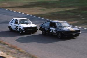 Bob Roth's ITA Chevy Citation X-11and Mark Utecht's ITB Dodge Omni head under the bridge