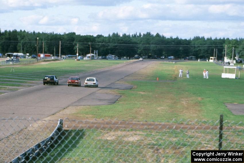 Bob Roth's ITA Chevy Citation X-11, Bill Fish's ITC Datsun 510 and Mark Utecht's ITB Dodge Omni go three-wide toward turn 10