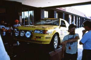 Tom Gillespie explains his roll with navigator Rick Beson in his Mazda 323GTX to a local bystander.