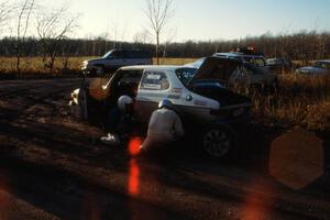 Tom Gillespie / Bill Smith change a tire at the finish of SS1 on their SAAB 99.