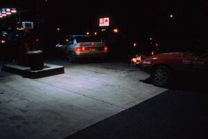 Barry Latreille / Sandy Latreille Ford Escort GT pull out from the pump as Bruce Newey / Kennon Rymer pull in their Mazda RX-7.