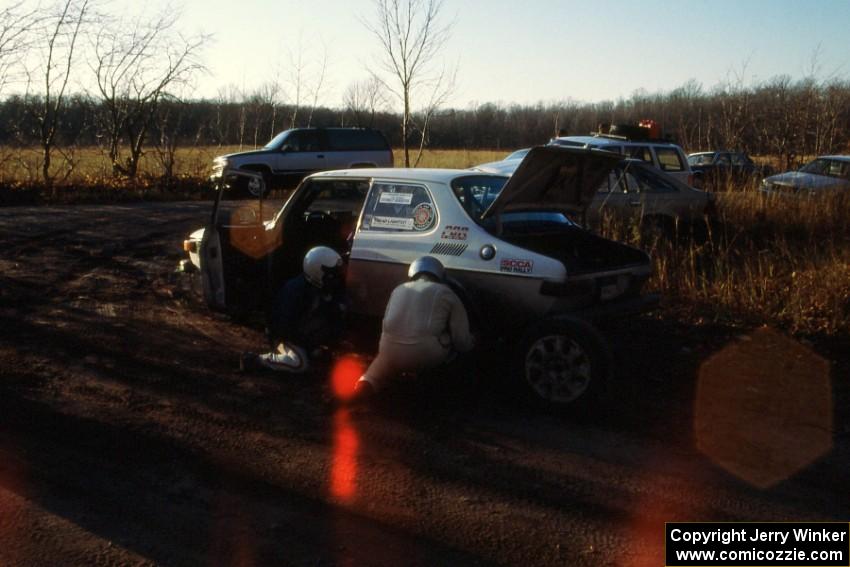 Tom Gillespie / Bill Smith change a tire at the finish of SS1 on their SAAB 99.