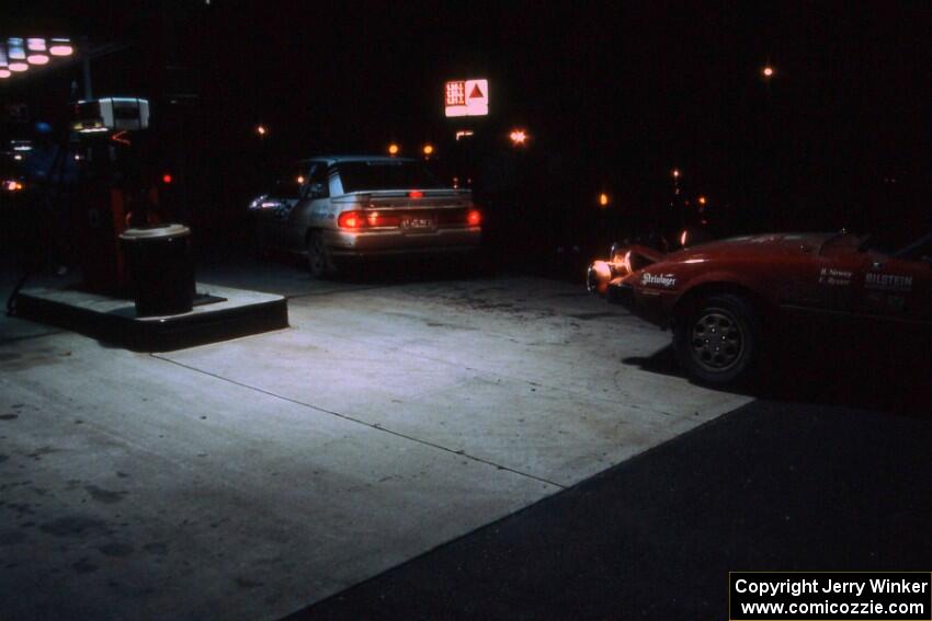 Barry Latreille / Sandy Latreille Ford Escort GT pull out from the pump as Bruce Newey / Kennon Rymer pull in their Mazda RX-7.