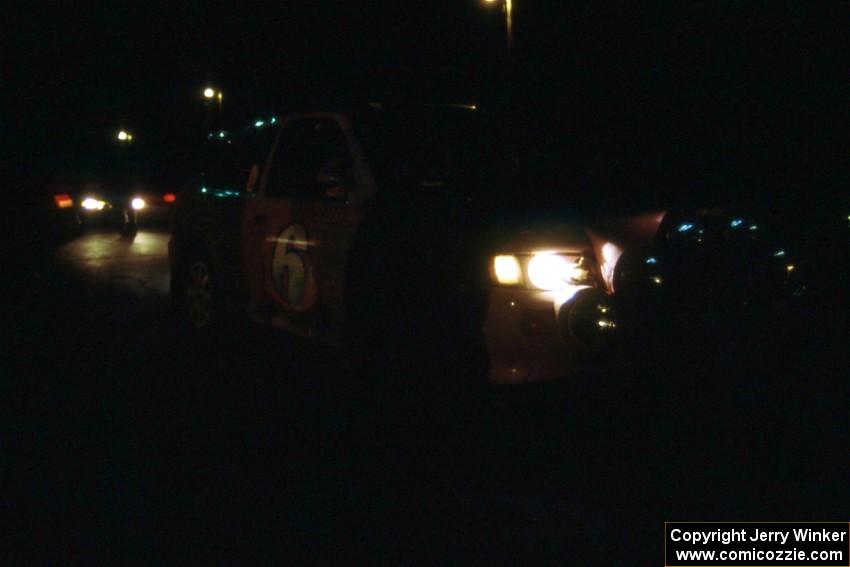 The Carl Merrill / Jon Wickens Ford Escort Cosworth RS sits in the dark before the control leaving L'Anse.