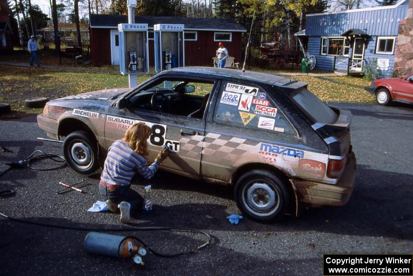 The Steve Gingras / Bill Westrick Mazda 323 GTX gets a rubdown from Diane Sargent.