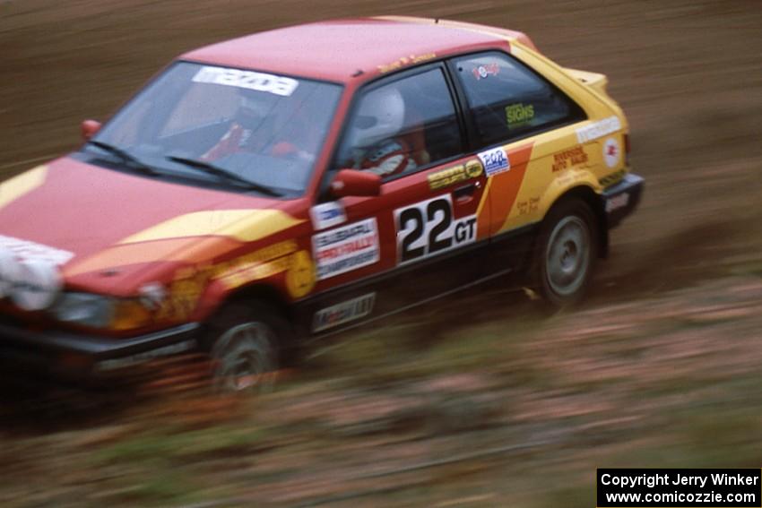 Stuart Sarasin / Craig Sobczak at speed through the spectator location on SS1 in their Mazda 323GTX.