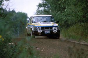 The Goran Ostlund / Steve Baker SAAB 99 comes over the last crest of the 3/4 mile straight and sets up for a left-hander.