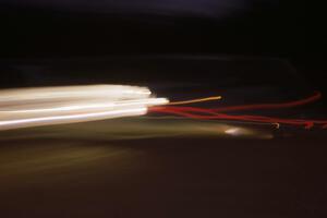 The Peter Moodie / Mike Fennell Mazda 323GTX at speed at night on day two.