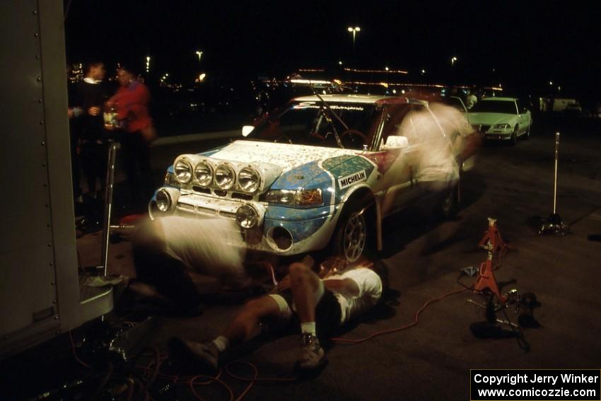 Mechanics are a blur on the Peter Moodie / Mike Fennell Mazda 323GTR at service on day one.