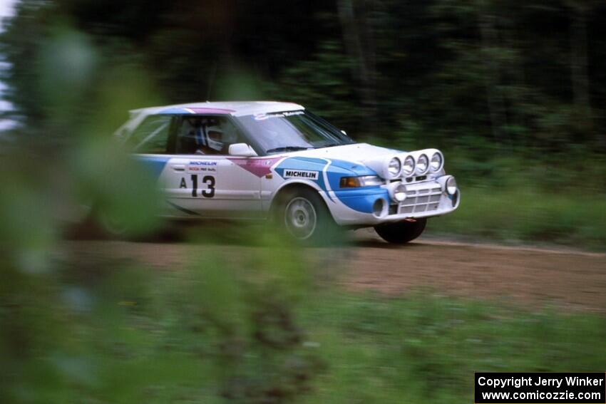 The Peter Moodie / Mike Fennell Mazda 323GTR drifts into the spectator area at the county road.