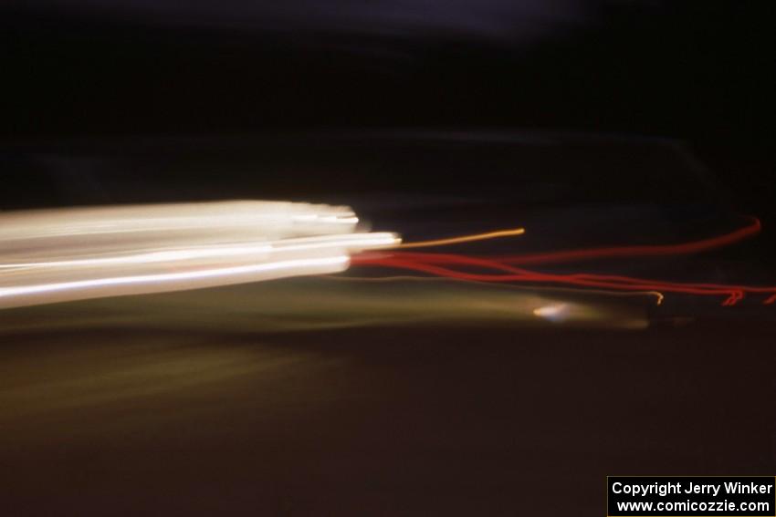 The Peter Moodie / Mike Fennell Mazda 323GTX at speed at night on day two.