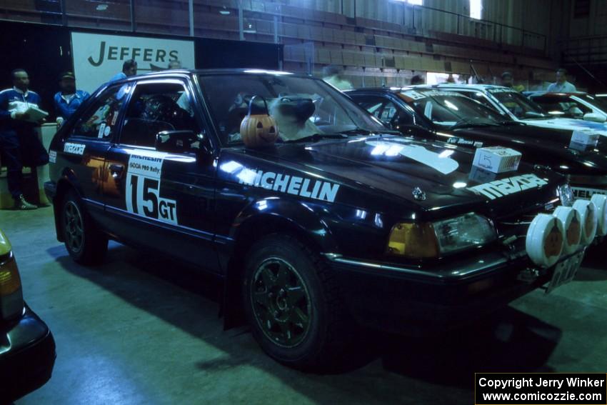 A festive Tom Ottey / Pam McGarvey in their Mazda 323GTX at parc expose (1).