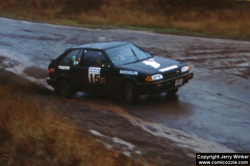 Tom Ottey / Pam McGarvey in their Mazda 323GTX slide wide at the Delaware delta.