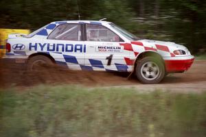 Paul Choiniere / Jeff Becker accelerate their Hyundai Elantra away from the spectator point on the county road.