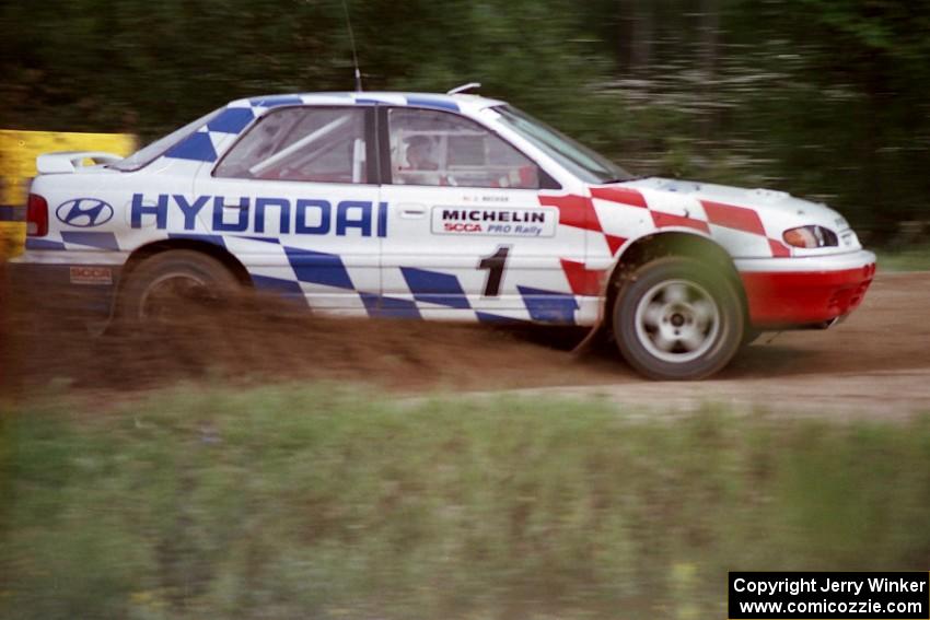 Paul Choiniere / Jeff Becker accelerate their Hyundai Elantra away from the spectator point on the county road.