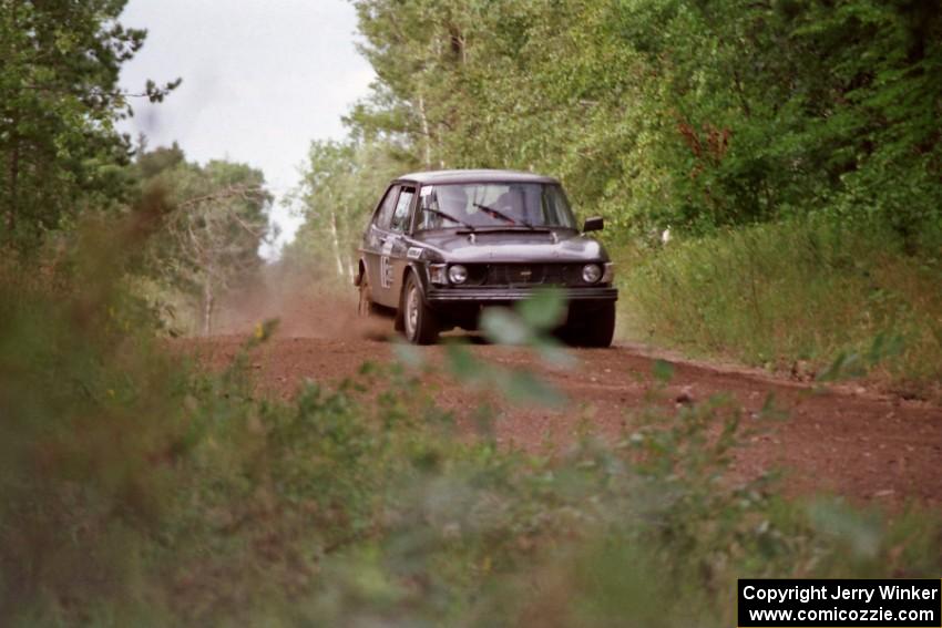 The Jerry Sweet / Stuart Spark SAAB 99EMS comes over a crest on Indian Creek Trail Rd.