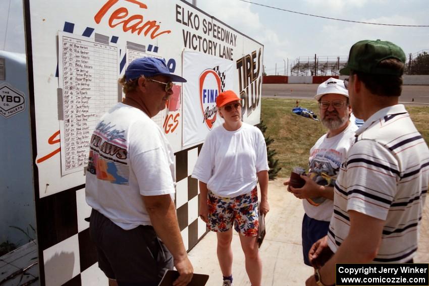 Conversing at the results boards: L to R) Don Gettinger, Becky Nazario, Sean Coleman and Gary Schmidt