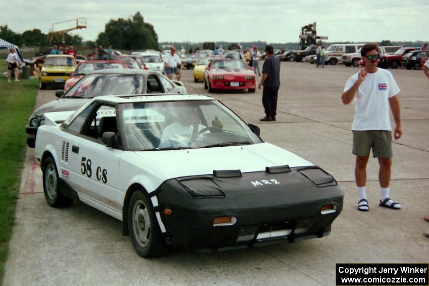 Glenn Ciegler talks to Dean Granros seated in his in his Toyota MR-2 at the start line