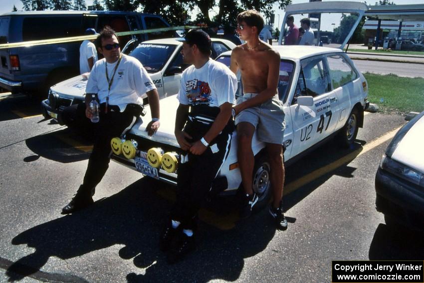 Joe Huttle, Todd Erickson and Fritz Wilke on the hood of the Ford Fiesta that the first two mentioned co-drove.