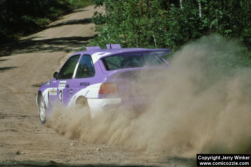Carl Merrill / John Bellefleur blast uphill out of a fast right at the crossroads in their Ford Escort Cosworth.