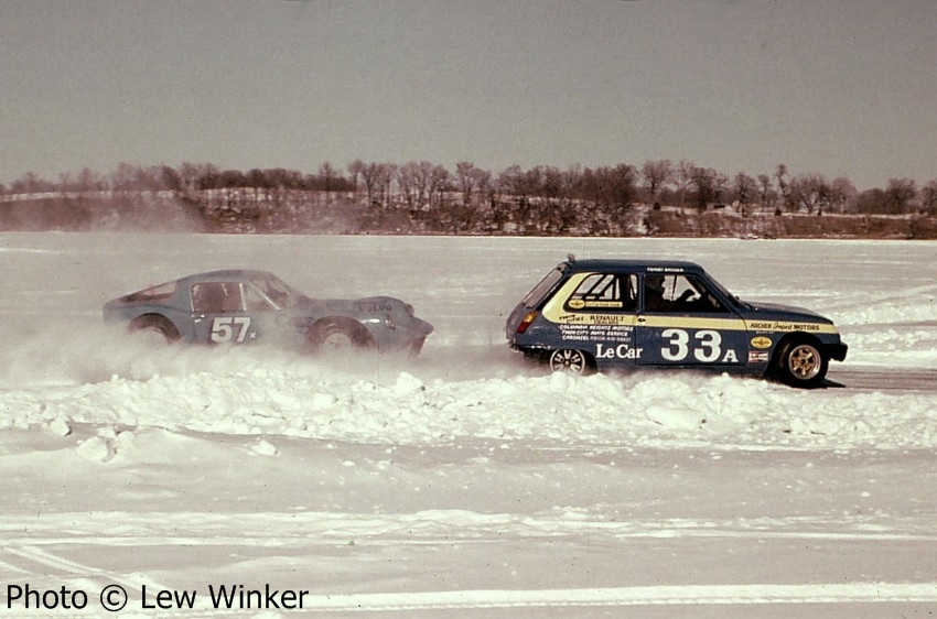 Tommy Archer's Renault LeCar leads Steve Erickson's SAAB Sonett II into turn one on the first lap.