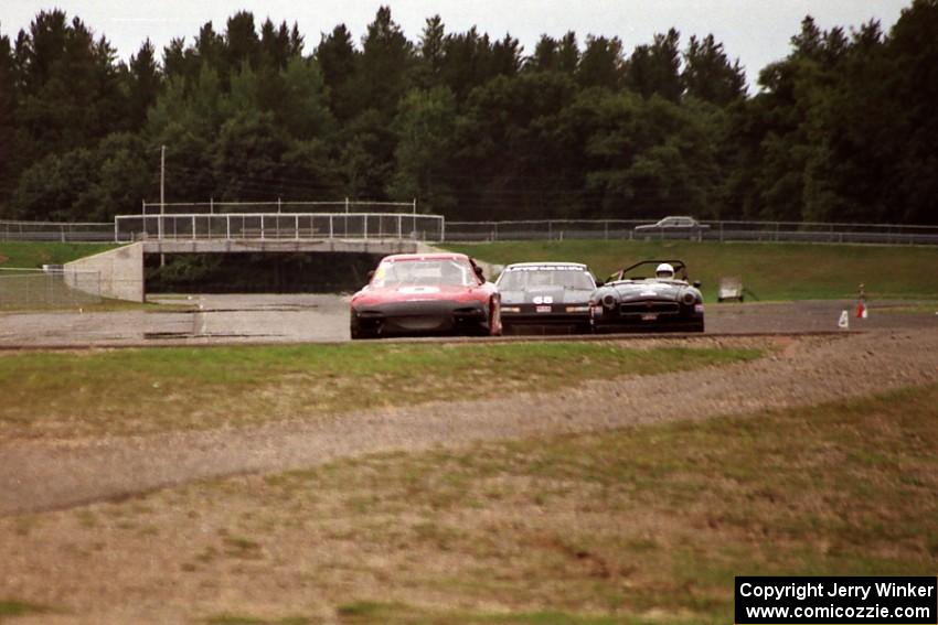 Doug Sherwood's GT-3 Mazda RX-7, Jim Courtney's GT-1 Olds Cutlass Supreme and Mike Froh's E Production MGB into turn 10