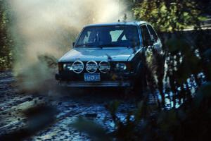 The VW Rabbit of Heikke Nielsen / Bob Nielsen hits a puddle before the final Menge Creek bridge.