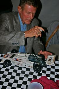 Bobby Unser signs the wing of a model of his 1974 Indy 500 Eagle. (2)