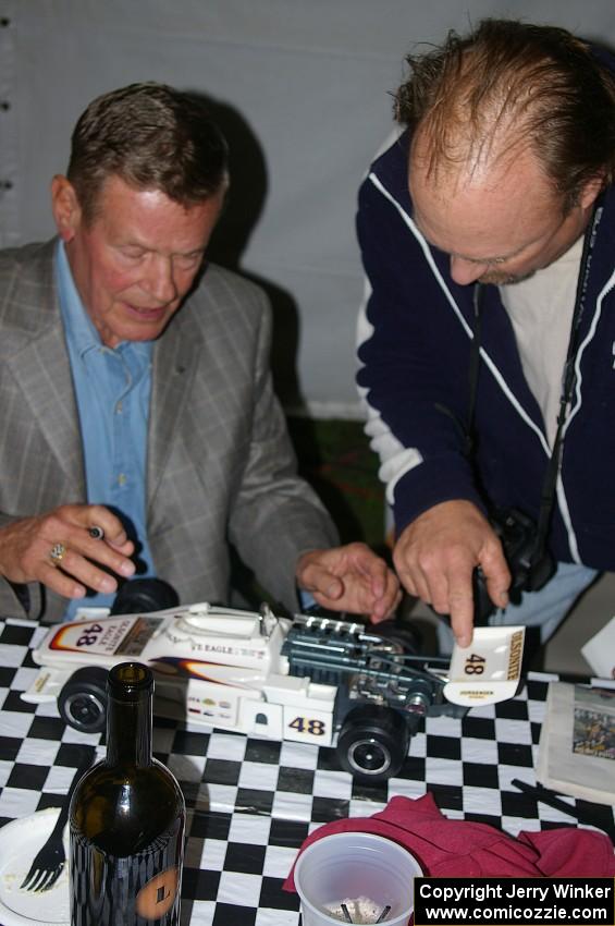 Bobby Unser signs the wing of a model of his 1974 Indy 500 Eagle. (1)
