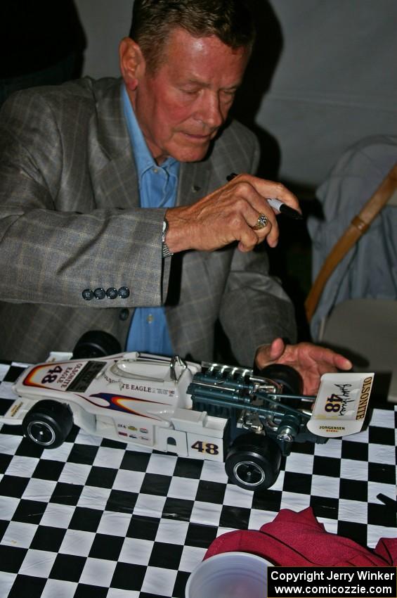 Bobby Unser signs the wing of a model of his 1974 Indy 500 Eagle. (2)