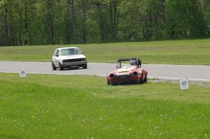 Don Haaversen's E Production Datsun 2000 pulls off the track before turn 4 as Jimmy Griggs' ITB VW Rabbit passes