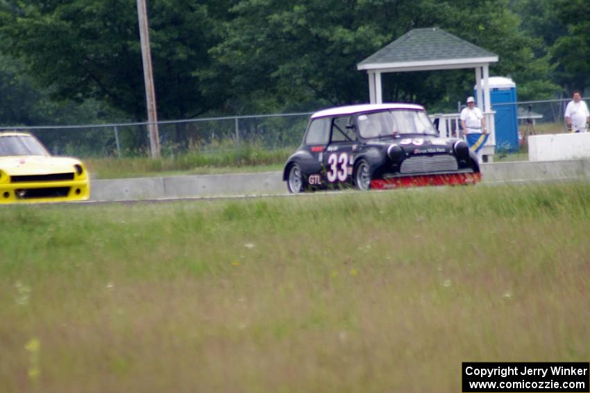 Terry Orr's GTL Austin Mini-Cooper leads Tim Homes' E Production Datsun 240Z out of turn 4