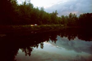 Leon Styles / John Dillon Mitsubishi Lancer Evo VII reflected against a lake on SS4, Blue Trail.