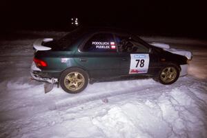 The Mark Podoluch / Kazimierz Pudelek Subaru Impreza drifts through the first corner of the evening running of the ranch stage.