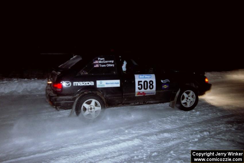 The Tom Ottey / Pam McGarvey Mazda 323GTX drifts through the first corner of the evening running of the ranch stage.
